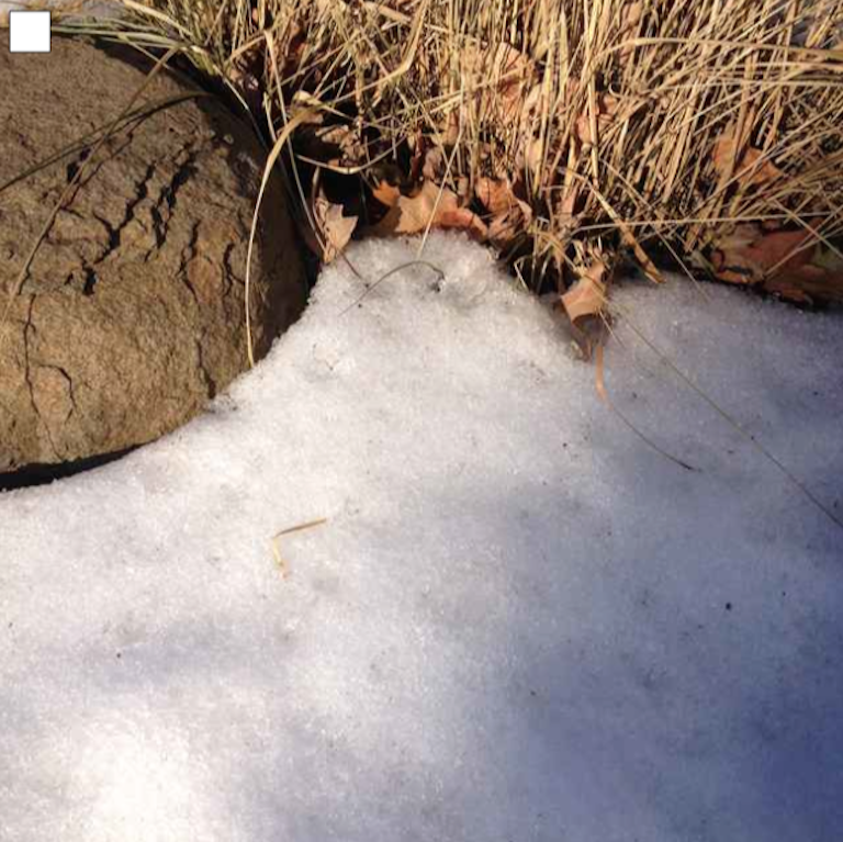 image of granular snow by rock